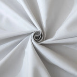 A close-up of Linenly’s Luxe Cotton Sateen Sheet Set in Silver showcases the light gray fabric, gathered and twisted into a spiral to reveal silky folds and soft shadows in its smooth sateen weave.
