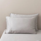 Two Linenly Bamboo Pillowcase Set - Silver pillowcases are neatly arranged against a light beige wall on a matching bed with smooth, wrinkle-free sheets, creating a calm, minimalistic scene.